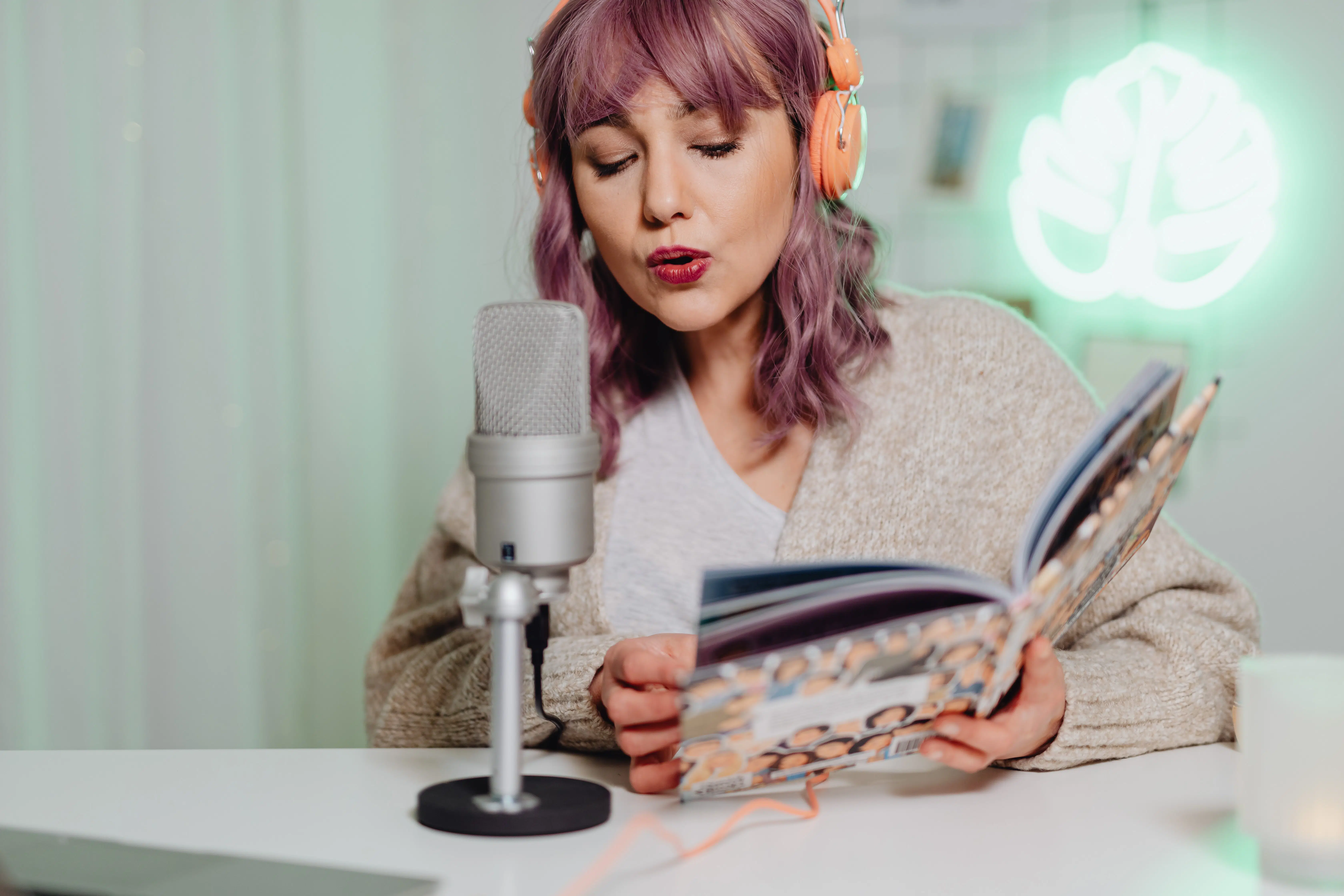 femme au cheveux rose qui fait un podcast